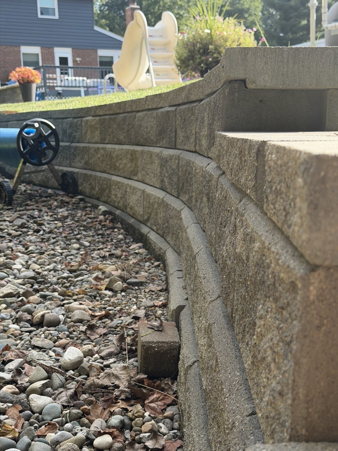 Curved segmental block retaining wall with river rock bed